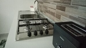 A kitchen with a gas stove, a toaster, and a sink.