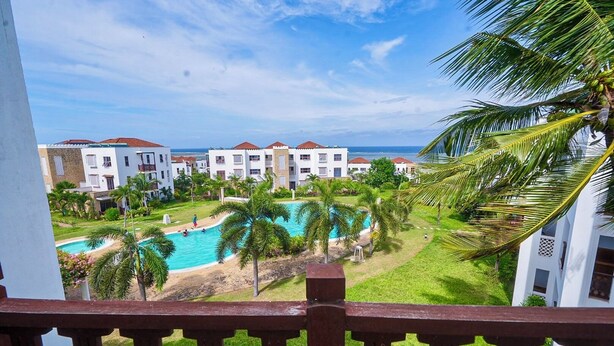A resort with a pool, palm trees, and a view of the ocean. - Serene 2bedroom Beach Apartment, Sultanpalace Kikambala. Northcoast Kilifi Kenya (Kikambala)