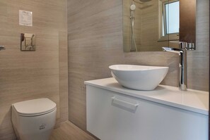 Une salle de bain moderne avec des toilettes blanches, un grand lavabo blanc et un miroir au-dessus du lavabo.