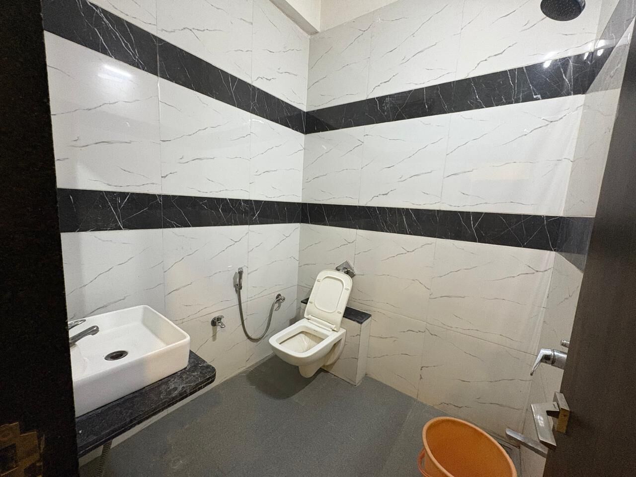 Een badkamer met toilet, wastafel en douche.