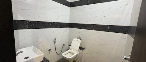 Een badkamer met toilet, wastafel en douche.