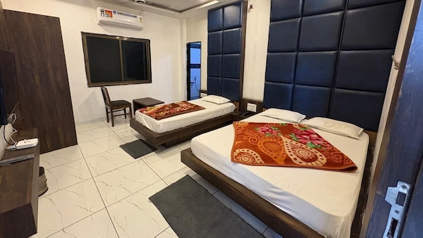 Una habitación de hotel con dos camas, un escritorio, una silla y un televisor.
