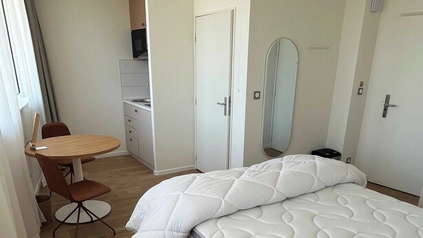 A bedroom with a bed, a desk, and a chair. - Comfort Studio in a Premium Residence- Sport/cinema (Huningue)
