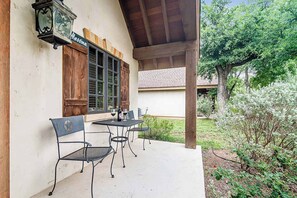 An outdoor patio with a table and chairs, a wooden bench, and a sign reading "Messina."