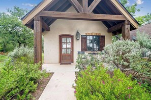 Un bâtiment de style rustique doté d’un porche en bois, d’une porte et d’une fenêtre avec des volets.