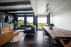 Ein modernes Wohnzimmer mit einem Holzesstisch, einer Couch und einem Couchtisch.