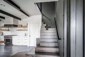 Una cocina moderna con armarios blancos, horno empotrado y encimera de madera.