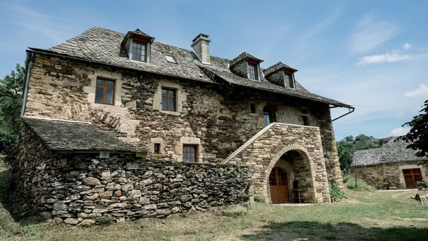 A stone building with multiple windows and a central arched entrance.
