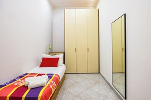 A hotel room with a bed, a wardrobe, and a mirror.