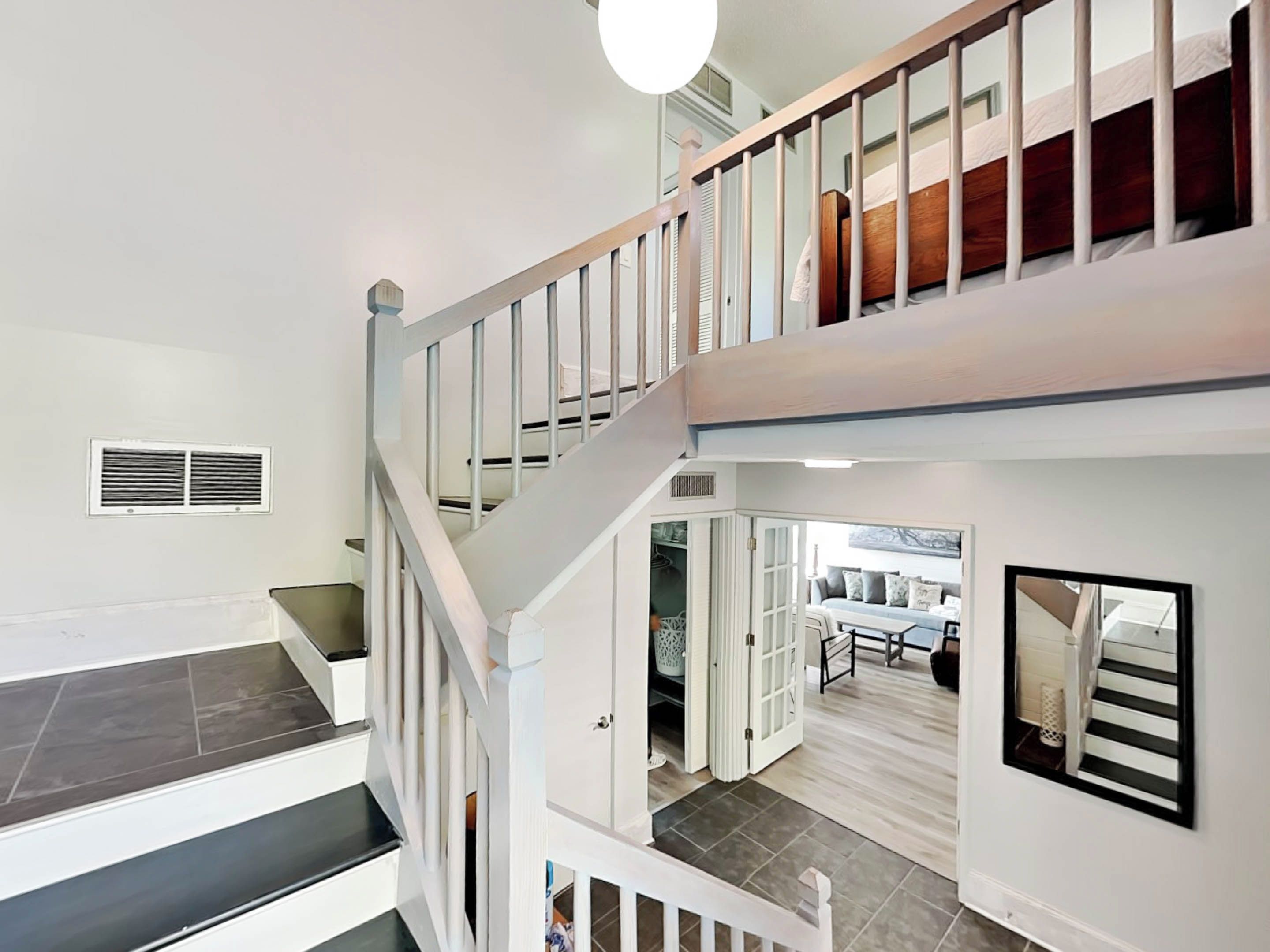 A multi-level interior with a staircase, a dining area, and a view of the outdoors.