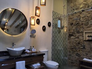 Ein Badezimmer mit einem großen Spiegel, zwei Waschbecken, einer Toilette und einer Dusche.