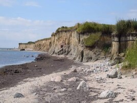 Una playa costera con un litoral rocoso y acantilados.
