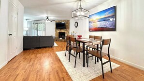 A dining area with a wooden table and chairs, a chandelier, and a painting on the wall. - Charming 2-bedroom townhome with AC, WiFi in lovely Jacksonville (Jacksonville)