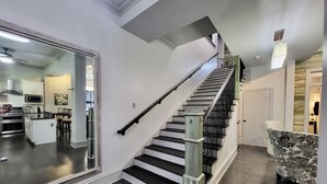 Un interior moderno con una escalera, una zona de cocina y un área de descanso.