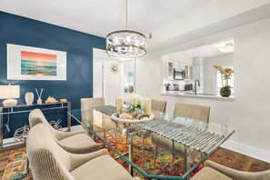 A modern dining area with a glass table, beige chairs, and a colorful rug. - Newly Updated, Walk to Siesta Key Beach, Tennis, Heated Pool (Siesta Key)