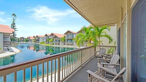 A balcony with a view of a swimming pool, adjacent buildings, and a clear sky. - Newly Updated, Walk to Siesta Key Beach, Tennis, Heated Pool (Siesta Key)