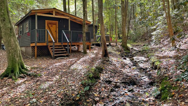 Eine Holzhütte mit einer Holzterrasse, einer Treppe und einer Tür mit der Aufschrift "28B".