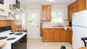 A kitchen with wooden cabinets, a white stove, and a refrigerator.