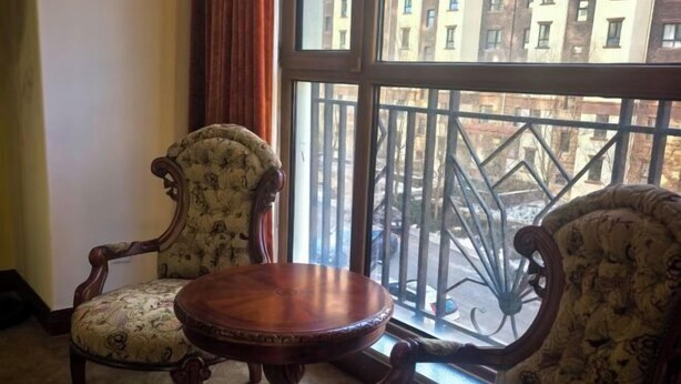 Une pièce comprenant deux fauteuils rembourrés et une table en bois.