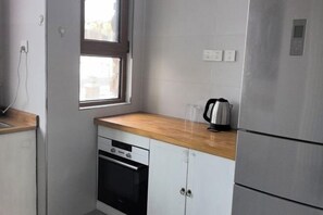 Una cocina compacta con horno empotrado, lavavajillas y refrigerador.
