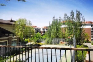 Un patio con una cancha de baloncesto, rodeado de árboles y edificios.