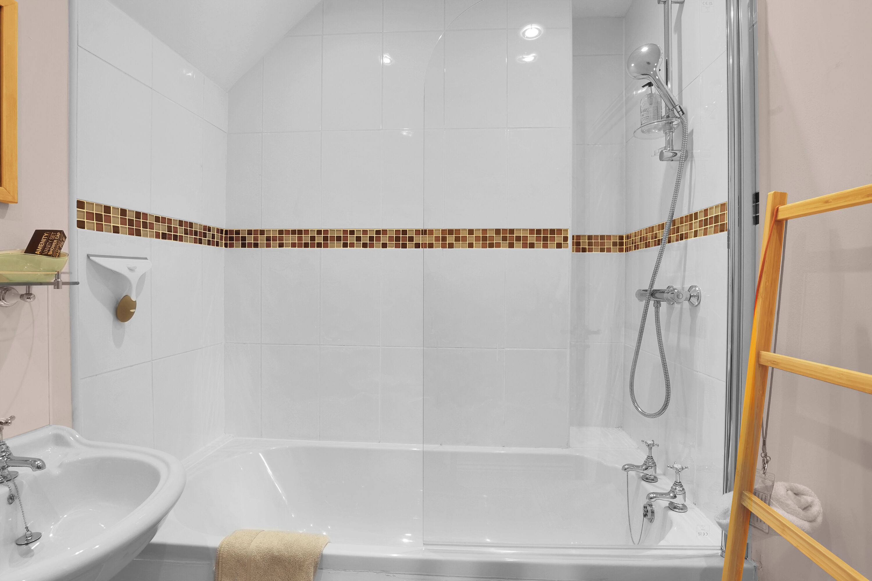 A bathroom with a glass-enclosed shower, two sinks, and a tiled backsplash.