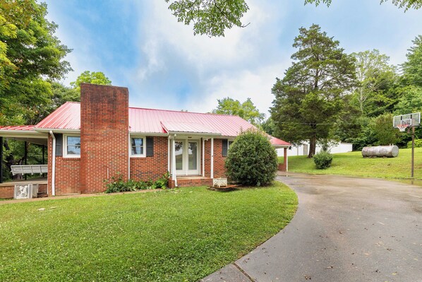 A single-story brick house with a red roof, a front porch, and a small front yard. - Red Robin Retreat - Near Lake James, NC (Morganton)
