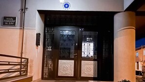 A staircase leading to a dark entrance with decorative panels and a sign indicating 'Strada Frunzelor Nr. 144'. - Luxorvilla studios (Constanta)
