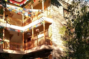 Un edificio de varios pisos con balcones, algunos con barandillas, y fachada de piedra.