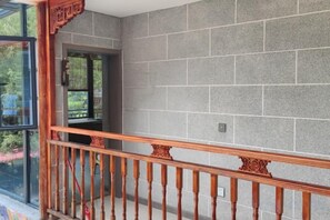 A staircase with wooden balusters leading to a landing with a glass door. - Ganbao Tibetan Village Jingji Chamayi Inn Homestay (Li County)