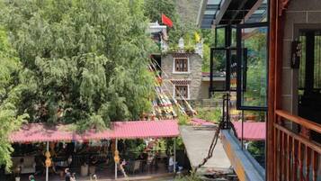 A traditional building with a red roof, a staircase leading to a higher level, and a balcony with a railing.