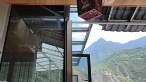 Une pièce dotée d’une grande porte vitrée donnant sur une vue imprenable sur la montagne.