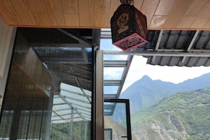 A room with a large glass door leading to a mountain view. - Ganbao Tibetan Village Jingji Chamayi Inn Homestay (Li County)
