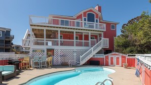 A two-story house with a pool, outdoor furniture, and a fenced deck. - Spacious Pet Friendly 6-bedroom all season retreat in Corolla w/ pool and sauna (Corolla)