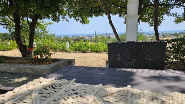Un sentiero nel giardino conduce a una zona relax con vista sul mare.