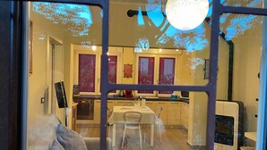 A cozy interior with a dining area, a sofa, and a pet area. - Appartamento Puccini (Grosseto)