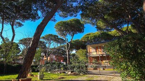 A residential area with a house surrounded by trees and greenery. - Appartamento Puccini (Grosseto)