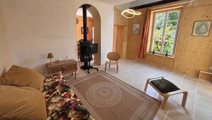 Een woonkamer met een bank, een salontafel, een televisie en een open haard.