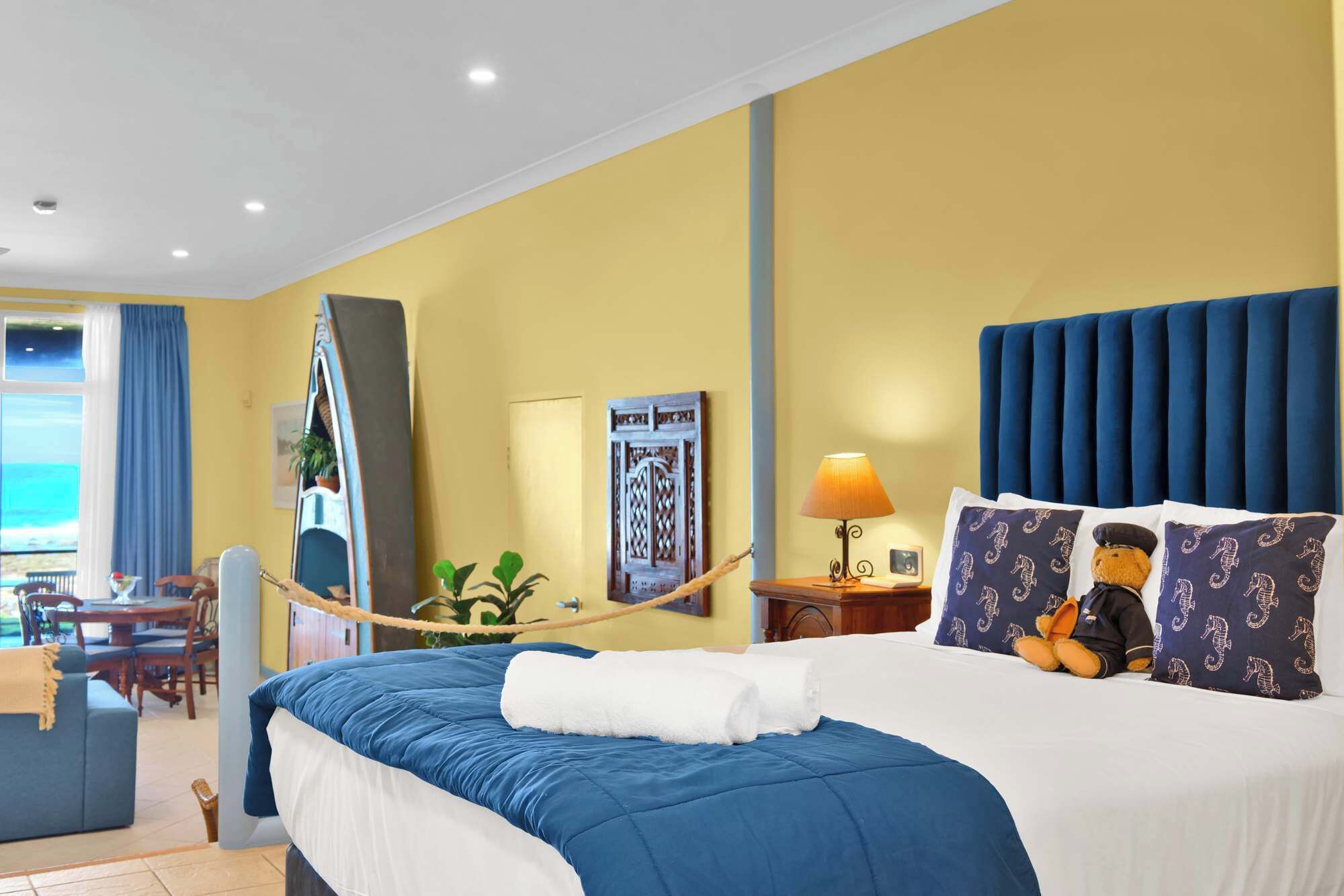 Una habitación de hotel con una cama, un escritorio y vistas al mar.