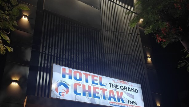 Une façade d’hôtel moderne, ornée d’une enseigne bien visible indiquant « HÔTEL THE GRAND CHETAK GROUP ».