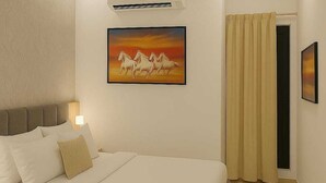 Une chambre à coucher avec un lit, un ventilateur de plafond, un appareil de climatisation, un tableau représentant des chevaux et une porte avec des rideaux.