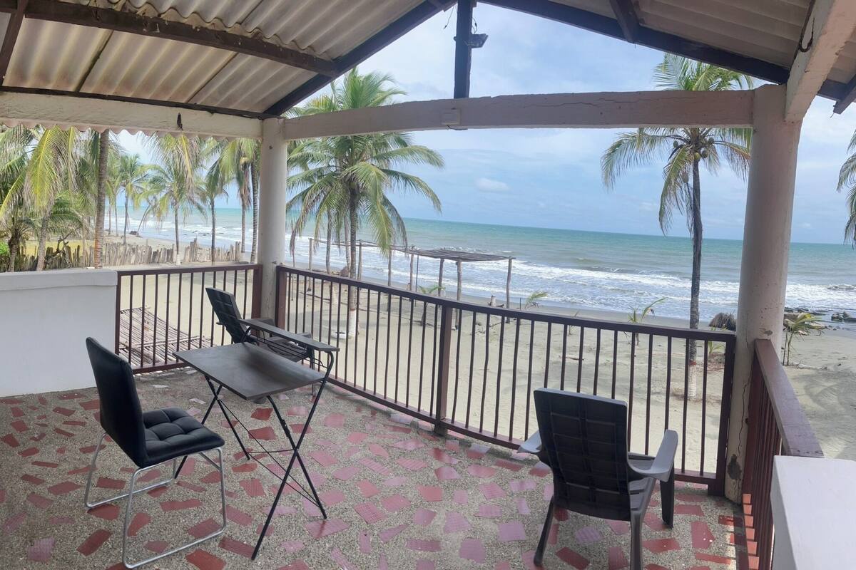 Ein überdachter Balkon mit Blick auf Strand und Meer.