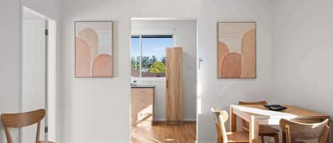 Un interior moderno con comedor, muebles de madera y obras de arte en las paredes.