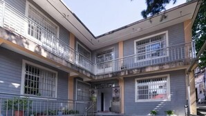A multi-story residential building with balconies, a central staircase, and a courtyard.
