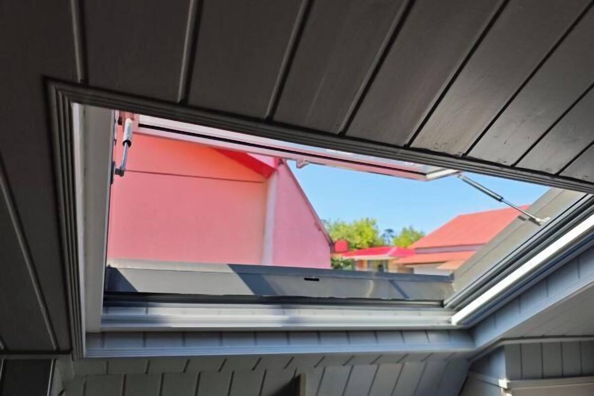 Une lucarne dans une pièce dont le plafond est en pente.