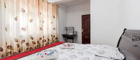 Un dormitorio con cama, escritorio y puerta.