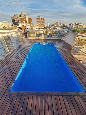 A rooftop swimming pool with a cityscape view.