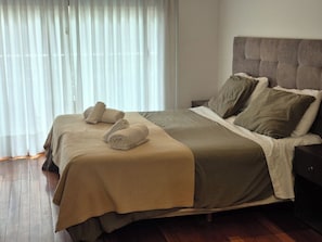 Una cama doble con cabecera, dos almohadas y una colcha.