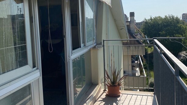 A balcony with a potted plant, a sliding glass door, and a view of the cityscape. - Near the sea central location, attic 3 floor elevator climate. (San Benedetto del Tronto)