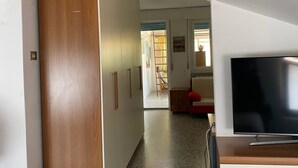 A hallway with a wooden door, a TV on a wooden stand, and a tiled floor. - Near the sea central location, attic 3 floor elevator climate. (San Benedetto del Tronto)